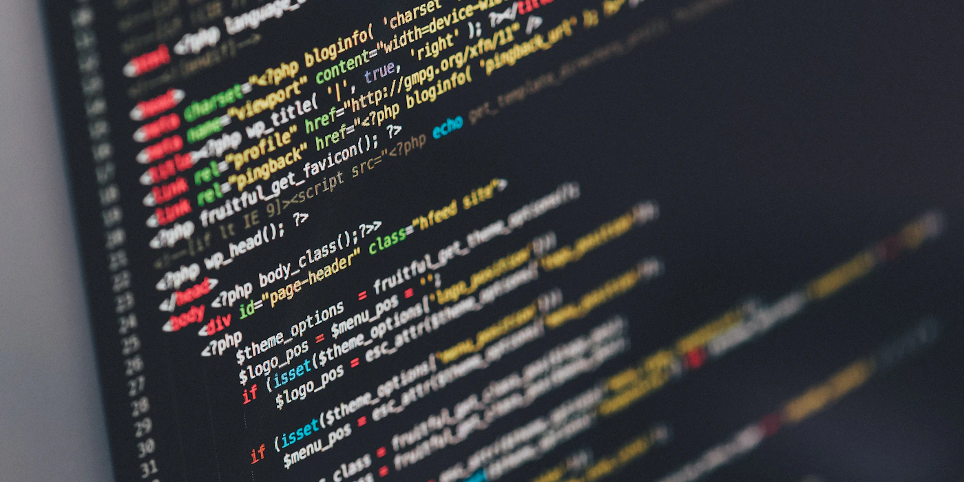 Close-up van de broncode van een website op een beeldscherm — de code die op onze servers draait.
